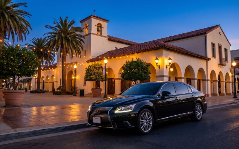 Lexus Sedan parked on a historic street with Mission Revival architecture at blue hour